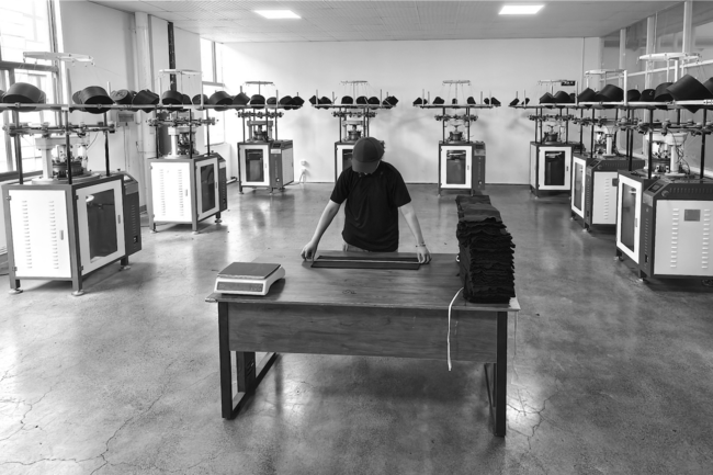 A man working on a table in the middle of a fabrics room