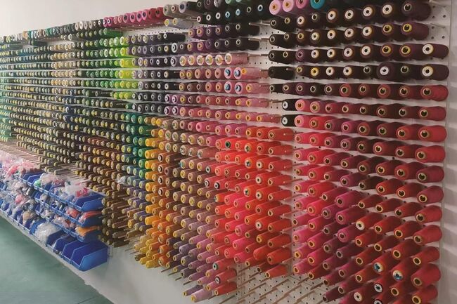 An image of fabric spools hung up on a wall